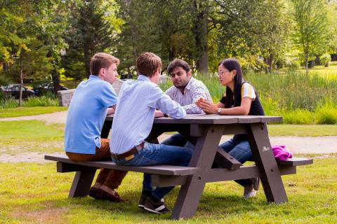 students at picnic table in park
