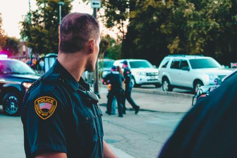 Police Officer in black uniform observing other officers