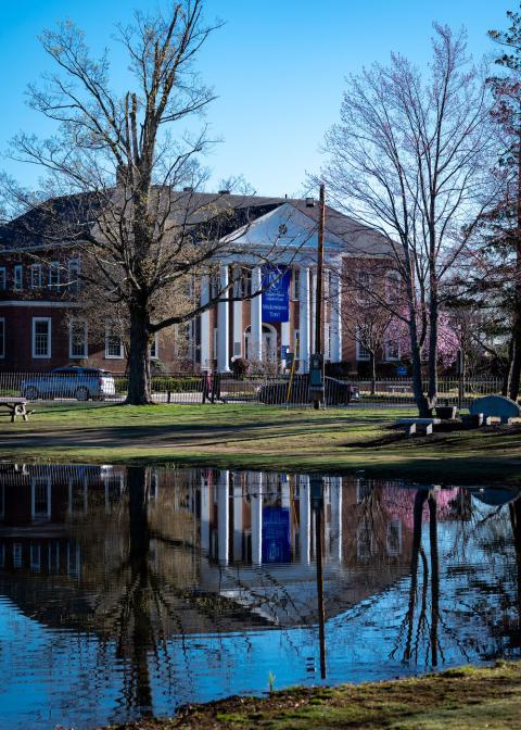 The front of the law school reflecting in the White Park pond