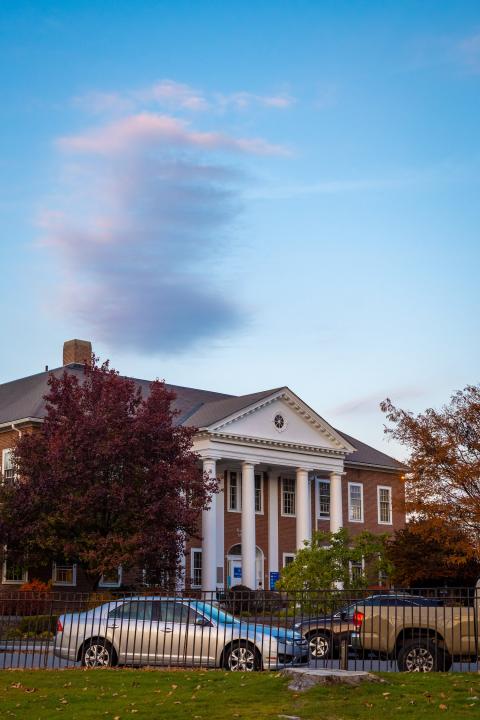 Front of the law school at fall with purple cloud above it